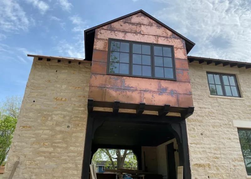 Copper metal panel facade on a stone building for Skylight Installation in Bastrop